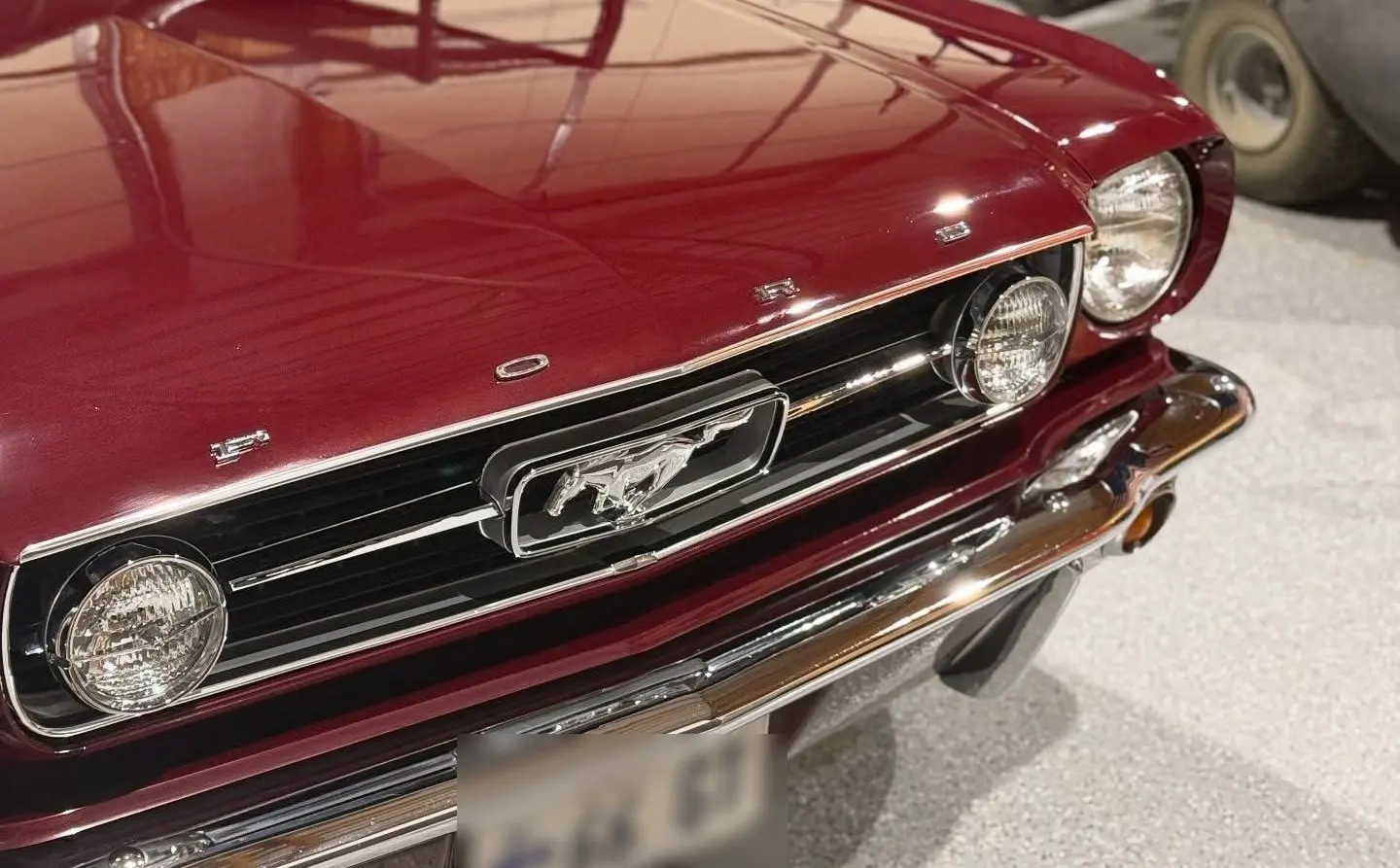 The corrected front of a maroon 1966 Mustang GT, deep gloss on classic paint