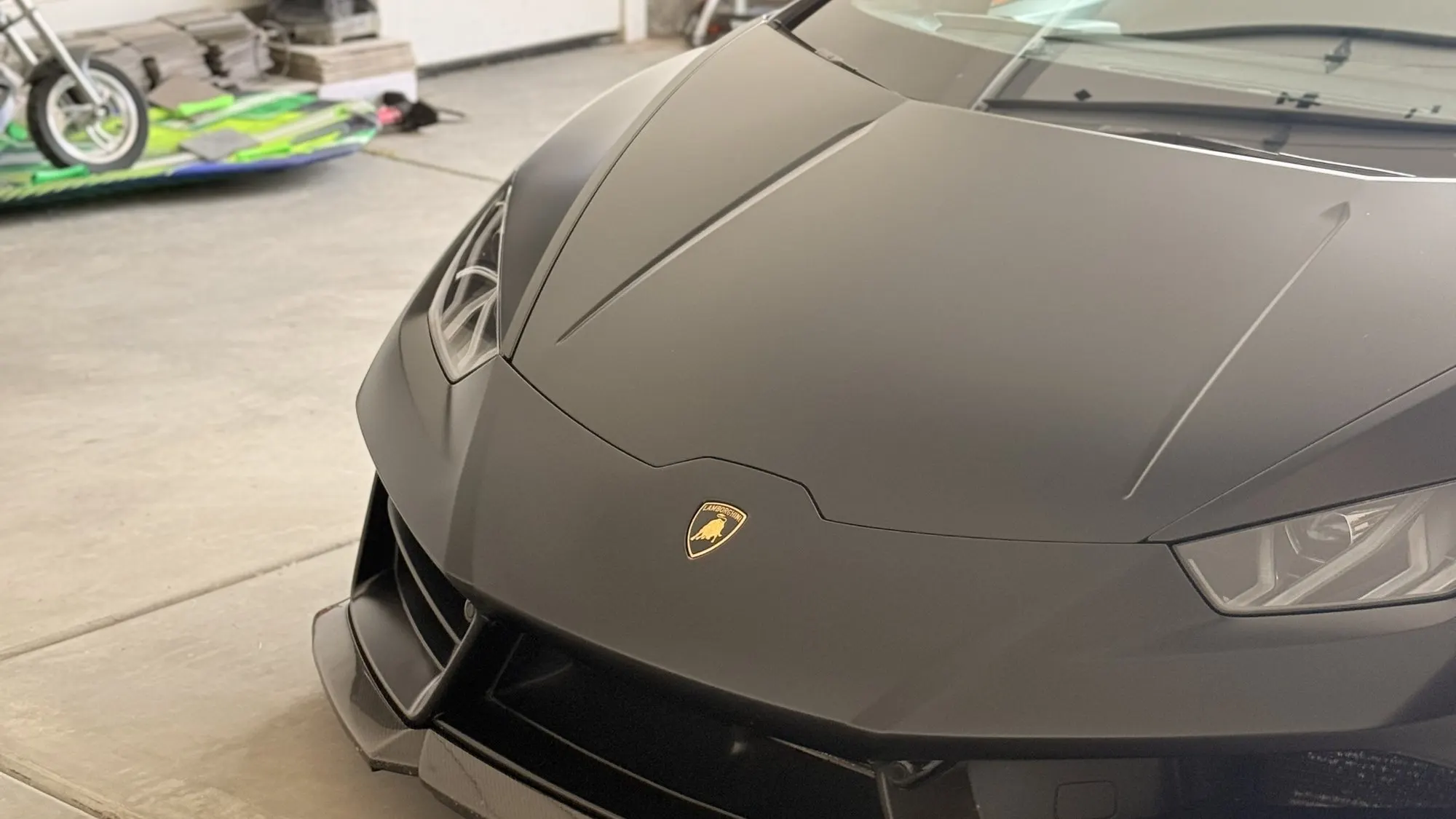 The matte black nose of a Lamborghini Huracan, front end square to the camera