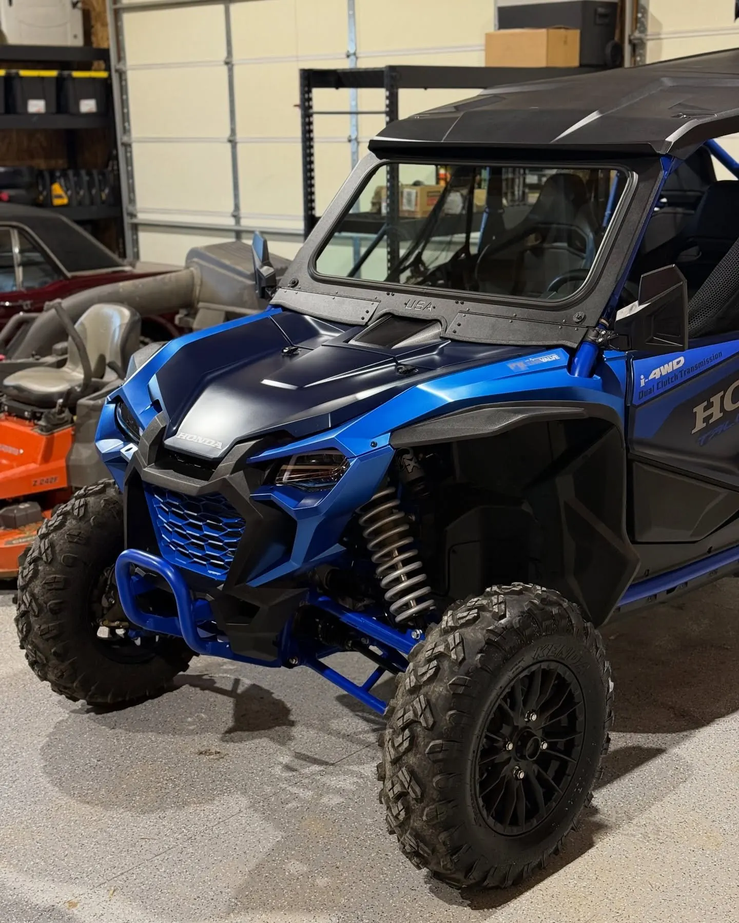 A blue and orange Honda Talon side-by-side from the front three-quarter