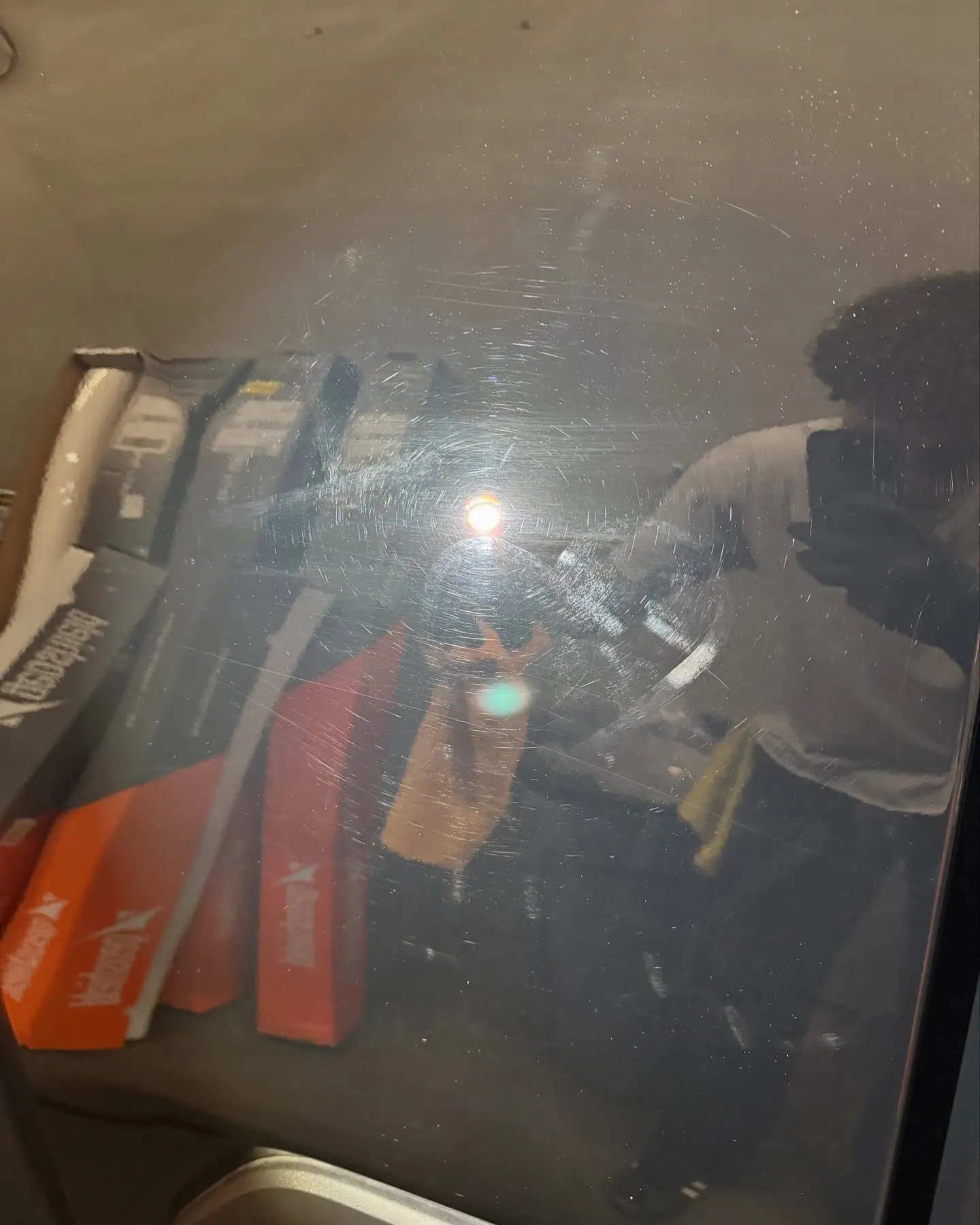 Dark tinted rear glass with the technician reflected in it
